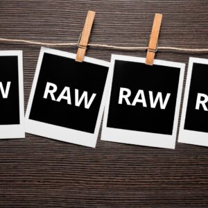 RAW feliratú fotók csipeszen, fa háttérrel.